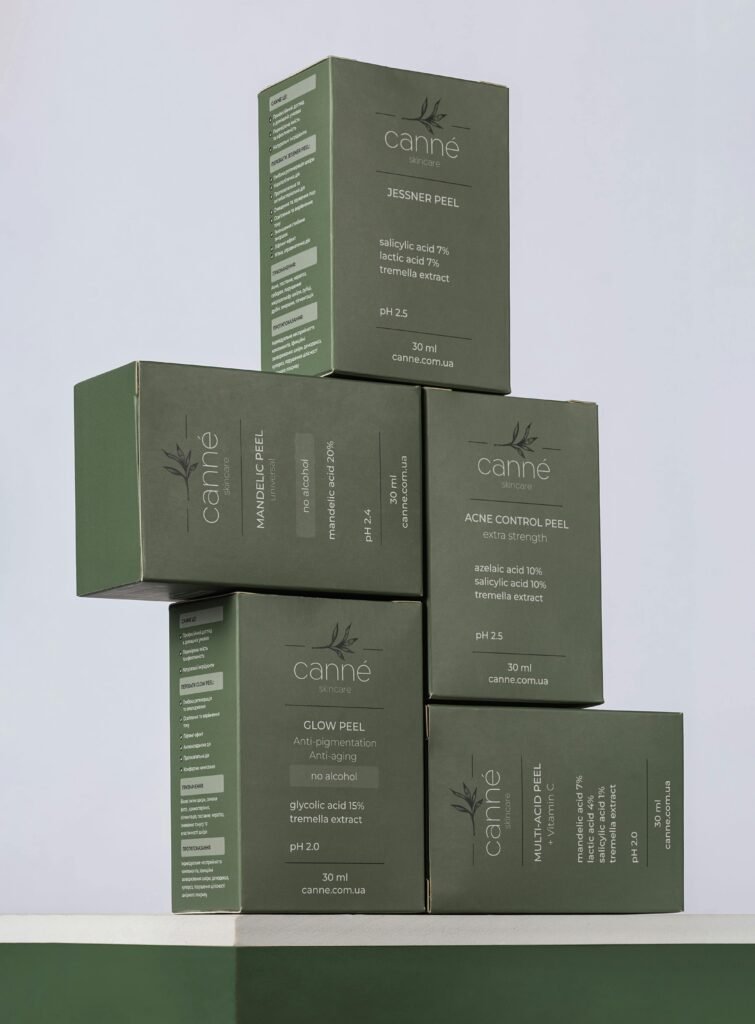 Close-up of stacked green boxes of skincare products by Canne featuring labels and benefits.
